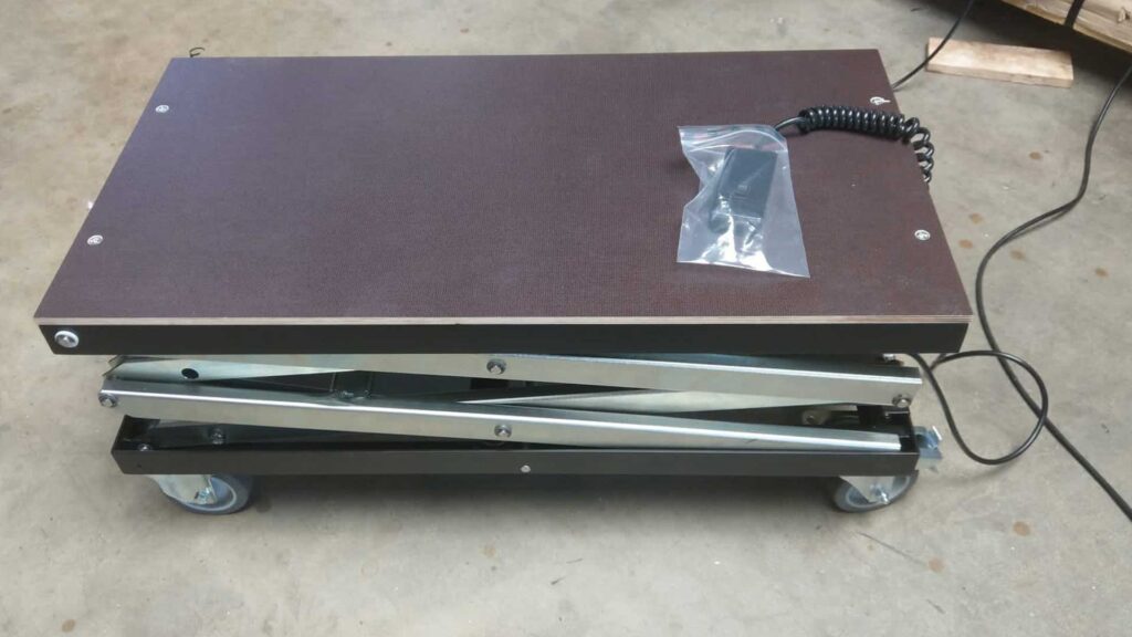 elektrischer Scherenhubtisch mit einer Siebdruckplatte als Plattformabdeckung & Fahrwerk